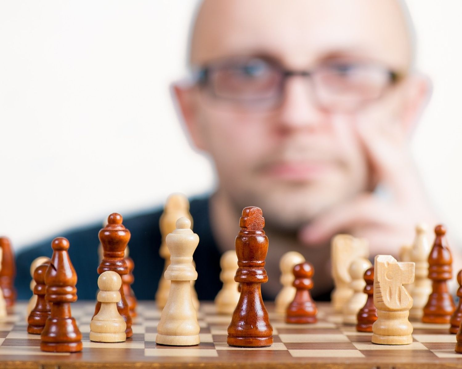 Homme devant un échiquier représentant la pensée stratégique pour atteindre ces objectifs